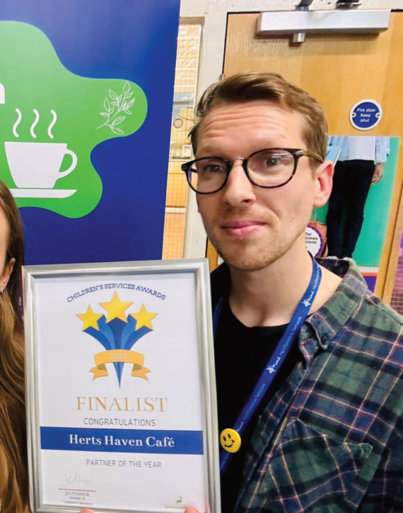our staff members Hannah and Mike are smiling at the camera and holding their Children's Services Award